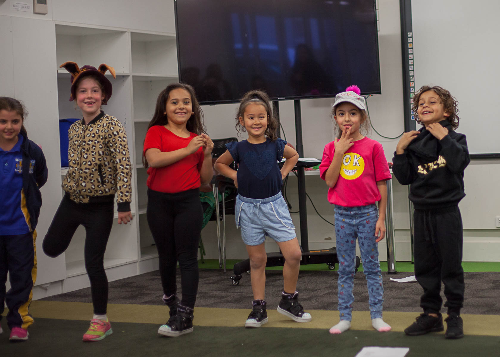 smiling kids acting on stage in an acting and drama class